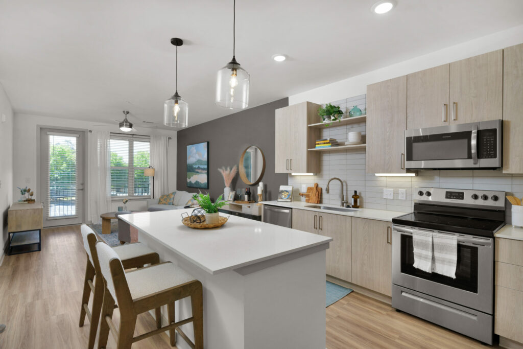 Celebrating Every Slice of Life - kitchen interior with chef's island, quartz countertops, stainless steel appliances, and modern backsplashes