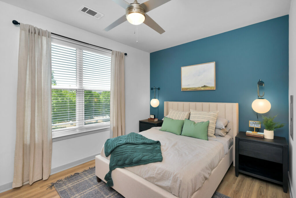 Elevate Your Way of Life - bedroom with lighted ceiling fans and hardwood-style flooring