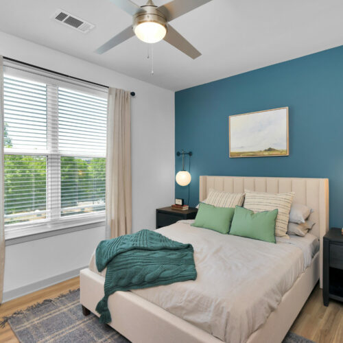 Elevate Your Way of Life - bedroom with lighted ceiling fans and hardwood-style flooring